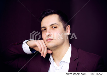 Serious young man on a dark background. Serious young man on a dark background. 48876529
