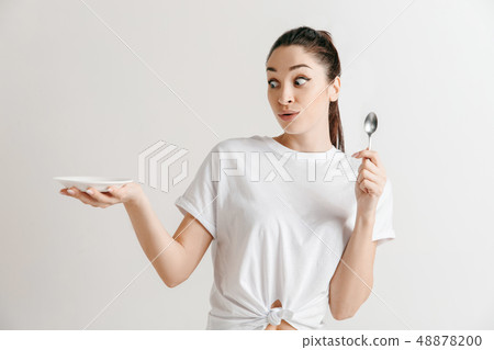 Young fun crazy brunette housewife with spoon isolated on white background 48878200
