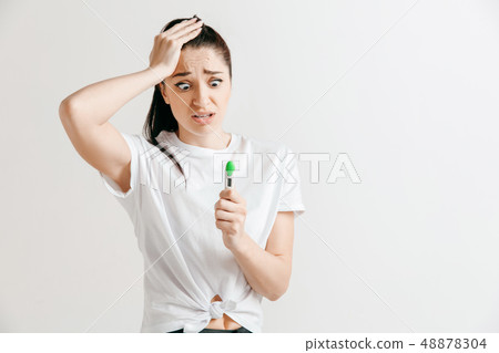 Young woman looking on pregnancy test Young woman looking on pregnancy test 48878304