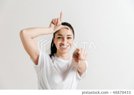 Losers go home. Portrait of woman showing loser sign over forehead Losers go home. Portrait of woman showing loser sign over forehead 48878433