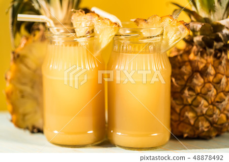 Pineapple juice and slice placed on a wooden table Pineapple juice and slice placed on a wooden table 48878492