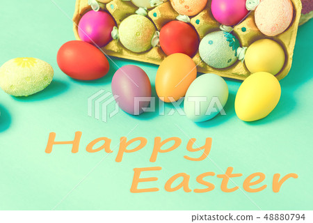 Bright Easter eggs lie in a box on a blue background 48880794