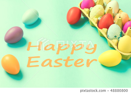 Bright Easter eggs lie in a box on a blue background 48880800