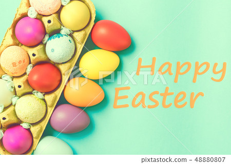 Bright Easter eggs lie in a box on a blue background 48880807