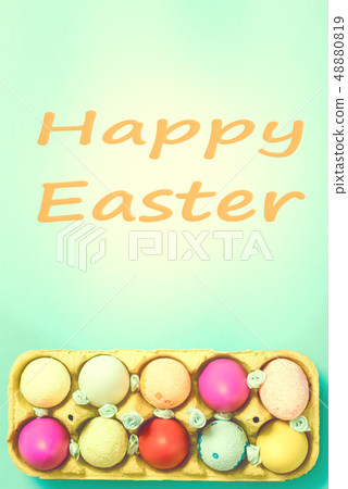 Bright Easter eggs lie in a box on a blue background 48880819