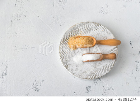 Scoops of brown and white sugar Scoops of brown and white sugar 48881274