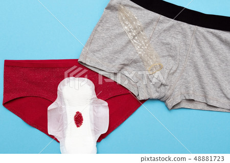 Red drop from beads on pants on blue background. Menstruation period 48881723
