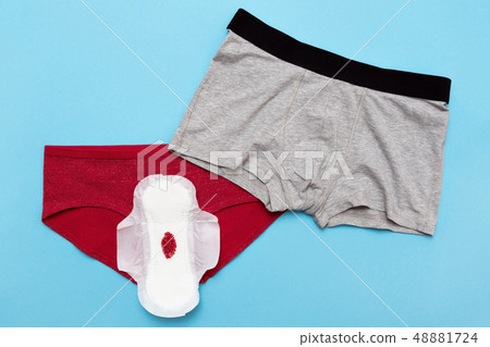 Red drop from beads on pants on blue background. Menstruation period 48881724