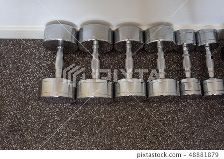 Dumbells on the floor in fitness room, 48881879