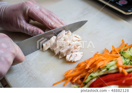 Chef cuts the vegetables into a meal. Preparing dishes. A man uses a knife and cooks. 48882128