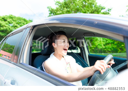 A woman driving a car 48882353