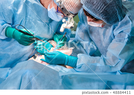 Portrait of a surgeon close-up. Surgeons operate on a patient. Tense, serious faces. Real operation Portrait of a surgeon close-up. Surgeons operate on a patient. Tense, serious faces. Real operation 48884411