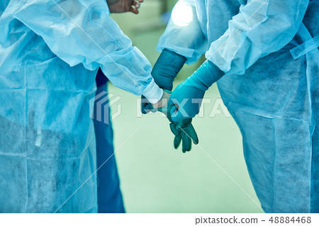 Surgeons wear sterile gloves before surgery 48884468