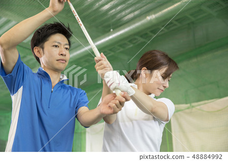 Women teaching golf at a driving range Women teaching golf at a driving range 48884992