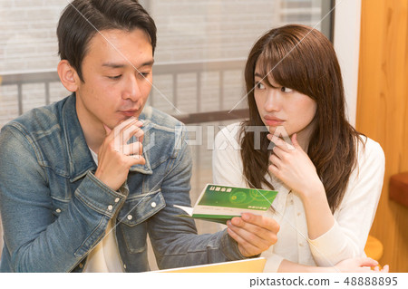 看銀行存款簿的男人和婦女 48888895