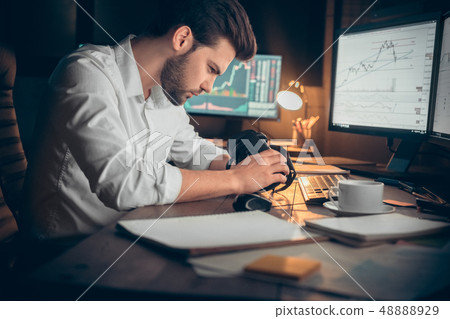 Young male trader at office work concept sitting holding virtual reality headset Young male trader at office work concept sitting holding virtual reality headset 48888929