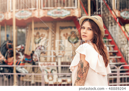 Ourdoors Leisure. Girl in hat standing at amusement park looking back camera pensive 48889204