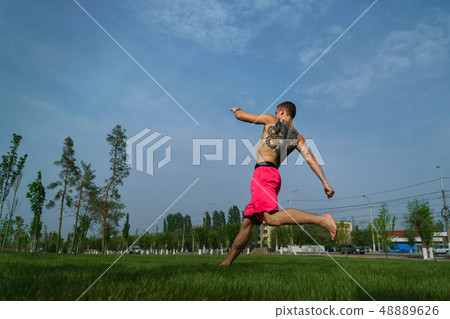 Tricking on lawn in park Tricking on lawn in park 48889626