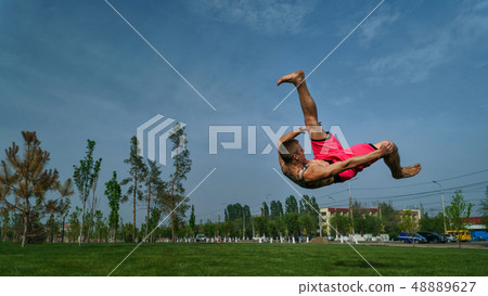 Tricking on lawn in park Tricking on lawn in park 48889627