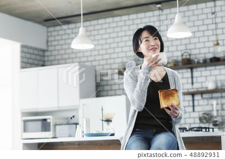 30's Woman Eating Breakfast In Dining Kitchen 48892931