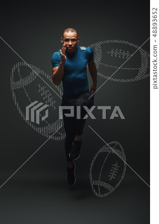 Build your strength. Handsome sportsman is ready to run jumping over dark background. Graphic Build your strength. Handsome sportsman is ready to run jumping over dark background. Graphic 48893652