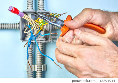 Cutting ends of wires  with long nose pliers. 48894944