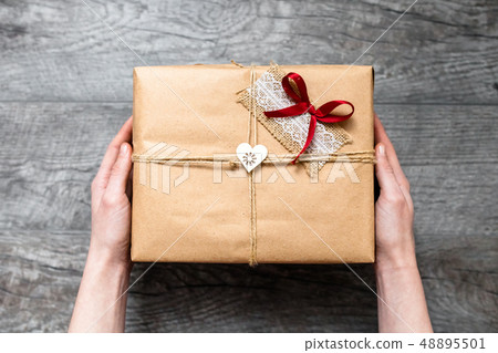 Female hand holding a wrapped gift  48895501
