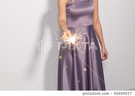 Event, celebration and holiday concept - Close up of woman hands holding sparkler 48899037