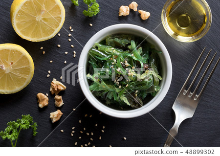 Fresh seaweed salad in a bowl on a dark background Fresh seaweed salad in a bowl on a dark background 48899302