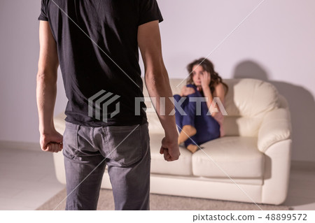 Domestic violence and abuse concept - man threatening with fist to crying woman 48899572