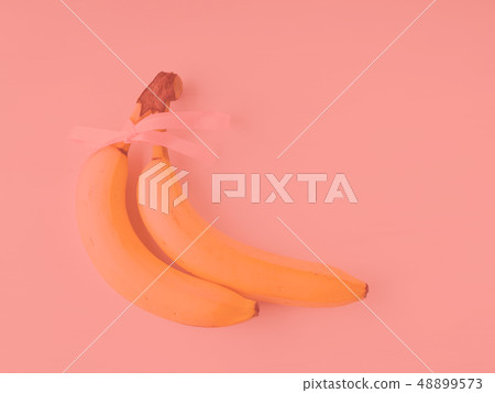 Two bananas with ribbon on pink 48899573