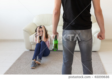 domestic violence, alcoholic and abuse concept - drunk man with bottle abusing his wife lying on the domestic violence, alcoholic and abuse concept - drunk man with bottle abusing his wife lying on the 48899686