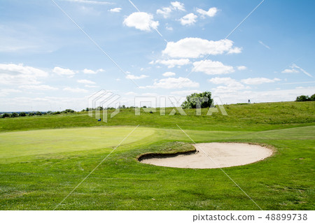 初夏高爾夫球場在藍天下綠旗與一面藍旗和一個大開的地堡 48899738