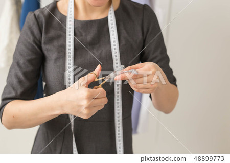 Dressmaker, fashion designer and tailor concept - Seamstress and her hands close up in workshop Dressmaker, fashion designer and tailor concept - Seamstress and her hands close up in workshop 48899773