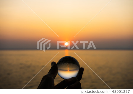 Crystal in silhouette hand with sunset sky at the 48901257