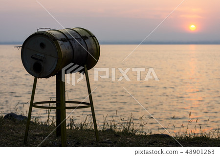 Silhouette Meat grill with blur sun and lake 48901263