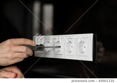 Close-up of an electrician's hand with a 48901338