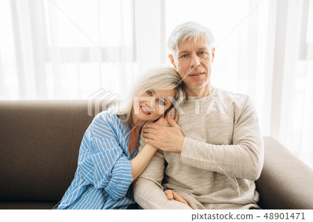 Mature husband and wife sitting on couch and hugs 48901471