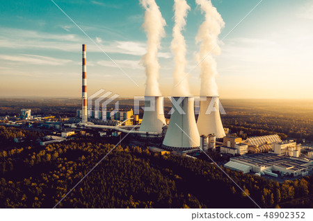 A Power plant with white smoke over it's chimneys A Power plant with white smoke over it's chimneys 48902352