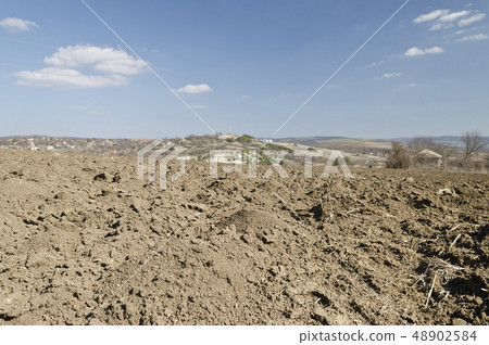 Plowed field in spring time with blue sky Plowed field in spring time with blue sky 48902584