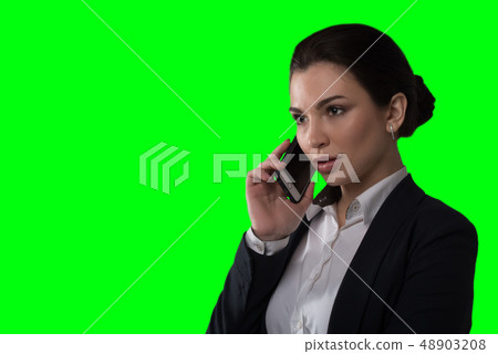 Young business lady speaks on the phone and works on green background 48903208