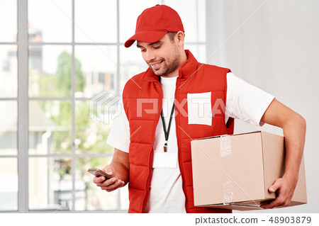 A satisfied customer is the best business strategy. Cheerful postman holding parcels and looking for A satisfied customer is the best business strategy. Cheerful postman holding parcels and looking for 48903879