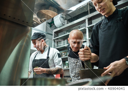 I'm watching you Strict chef in apron looking carefully how his assistant working at restaurant I'm watching you Strict chef in apron looking carefully how his assistant working at restaurant 48904041