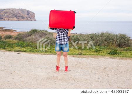 Holiday, travel and tourism concept - young woman with red suitcase over sea background Holiday, travel and tourism concept - young woman with red suitcase over sea background 48905187