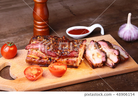 Sliced grilled pork ribs barbecue Striploin steak with chimichurri sauce and tomatoes on cutting Sliced grilled pork ribs barbecue Striploin steak with chimichurri sauce and tomatoes on cutting 48906154