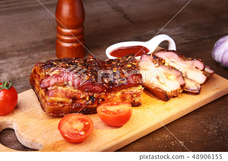 Sliced grilled pork ribs barbecue Striploin steak with chimichurri sauce and tomatoes on cutting Sliced grilled pork ribs barbecue Striploin steak with chimichurri sauce and tomatoes on cutting 48906155