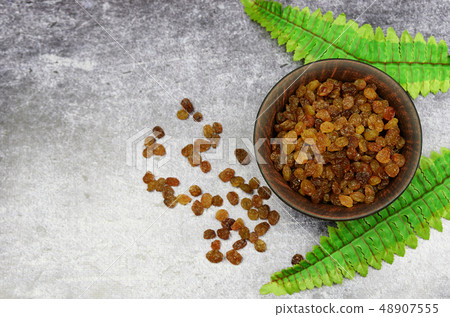 brown raisins in a plate  48907555