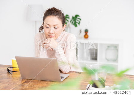 Senior woman looking at laptop computer Senior woman looking at laptop computer 48912404