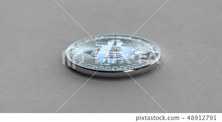 Bitcoin laying on flat surface. White metal coin. 48912791