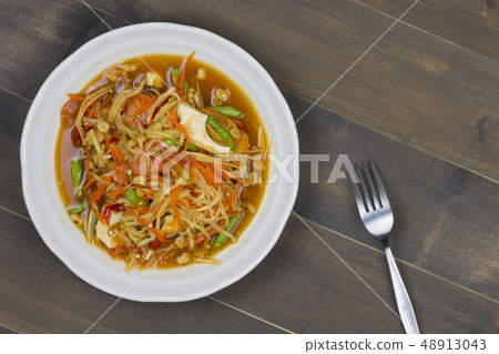 Thai spicy papaya salad on wooden table 48913043